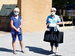 Photo by KEVIN McSHEFFREY/THE STANDARDDiane Bergeron and Linda Fredette are Meals on Wheels volunteers in Elliot Lake. They both drive on Thursdays. Fredette received a tote bag containing the meals she is to deliver, while Bergeron waits for her tote bag.
