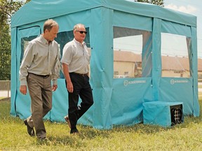 Marc Udeschini, left, of Nor Environmental International and Don Croteau of Schauenburg Industries Ltd. walk beside one of their 10-by-10 foot visitor pods. Submitted