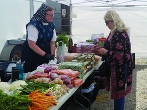 A customer buys produce from Linda Wipf of Parkland Colony on Saturday, when the Nanton and District Lions Club's first farmers' market of the season took place in the parking lot to the east of the Tom Hornecker Recreation Centre. The non-profit group agreed to host the market after the Nanton United Church's council had decided in May to not hold its farmers' market this year due to concerns around COVID-19. STEPHEN TIPPER