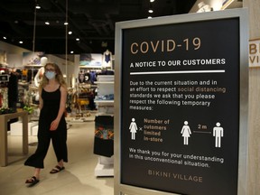 A "Covid-19" sign stands at the entrance of a retail store in Ottawa, on Friday, June 12, 2020.