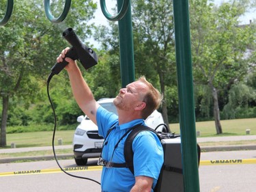 Stephan St-Andre electrostatically applies a eco-friendly, biodegradable but highly effective degreaser to the playstructure. Anthony Dixon