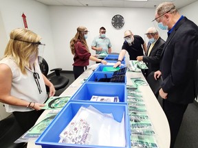 Following a tour through SRBT on July 28, provincial ministers John Yakabuski and Vic Fedeli (second from right) had a chance to check out the packaging process of medical face shields being created at the facility. Employees Sarah St-Pierre (right) and Lexxi Fitzpatrick were making the packages as vice-president Ross Fitzpatrick and president Stephane Levesque, who led the tour, explained the process.