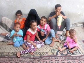 Wife and children of Abdullah al-Sharaabi, who has died of COVID-19, sit at their home in Aden, Yemen, on July 1. (Wael al-Qubati/Reuters)