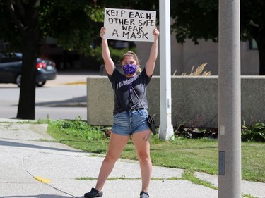 A person holds up a sign opposing a protest against Sarnia's mandatory mask bylaw on Thursday July 30, 2020 in Sarnia, Ont. Terry Bridge/Sarnia Observer/Postmedia Network