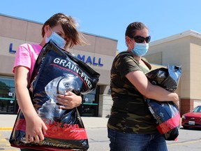 Tiffany Caughy and Jamie Caughy, 12, leave Lambton Mall with bags of dog food in this Sarnia Observer file photo. Lambton public health is hosting COVID-19 vaccine clinics in the mall, where the former Running Room was located, every Saturday through October 2021. (Terry Bridge/Sarnia Observer/Postmedia Network