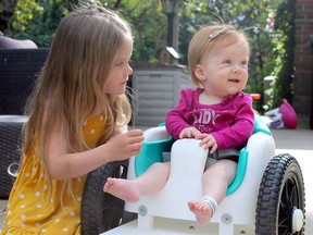 Harper Hanki sits outside with sister Kinsley, 3, during the Friday evening at their home in Parkland County. The GoFundMe for Hanki can be found by searching for "My Hero Harper - Spinal Muscular Atrophy Type 1" on the site.