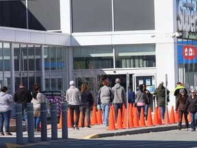 Shoppers patiently wait their turn to enter the Real Canadian Superstore in Sudbury, Ont. on Friday April 3, 2020.