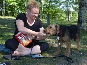 Chelsea Shepherd of Copper Cliff feeds her furry friend Gretchen, a one-year-old Airedale terrier, a snack while enjoying a shady spot in Lively. Jim Moodie/Sudbury Star