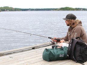 Shane Messier fishes off a dock on Ramsey Lake near Science North in Sudbury, Ont. on Monday July 13, 2020.