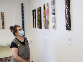 Exhibit curator Elizabeth Holmes checks over artwork on display at an exhibition at the North Forte and Artworks Studio/Gallery at 122 Durham St. in Sudbury, Ont. The Long Thin Show, which continues every Tuesday and Wednesday until August 26, 2020, features artwork from 31 Northern Ontario artists.