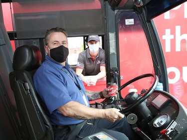 Ron Duchesne, left, a transit driver with the City of Greater Sudbury, collects his order from Connor McNally at a Tim Hortons drive-thru trailer at the City of Greater Sudbury's facility on Lorne Street in Sudbury, Ont. on Thursday July 16, 2020. Tim Hortons set up the trailer as a way of giving back to Sudbury GOVA transit employees "who have been working tirelessly throughout the pandemic to make sure other essential workers and residents are able to get around their city," said a release from Tim Hortons. John Lappa/Sudbury Star/Postmedia Network