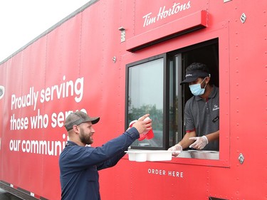 Mike Graff, left, a technician with the City of Greater Sudbury, collects his order from Tony Martin at a Tim Hortons drive-thru trailer at the City of Greater Sudbury's facility on Lorne Street in Sudbury, Ont. on Thursday July 16, 2020. Tim Hortons set up the trailer as a way of giving back to Sudbury GOVA transit employees "who have been working tirelessly throughout the pandemic to make sure other essential workers and residents are able to get around their city," said a release from Tim Hortons. John Lappa/Sudbury Star/Postmedia Network

Tim Hortons is giving back to Sudbury GOVA transit operators who have been working tirelessly throughout the pandemic to make sure other essential workers and residents are able to get around their city. Earlier this week, the coffee trailer visited TorontoÕs TTC Mount Dennis Transit Yard and now it is travelling North! 

Tim Hortons created a unique, one of a kind, drive-thru coffee trailer to say thank you to those who continue to keep our city moving.