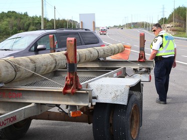 Dean Belisle, district enforcement manager for the MTO, inspects a rig as part of a commercial motor vehicle blitz on MR 80 in Greater Sudbury, Ont. on Friday July 17, 2020. Greater Sudbury Police and the Ontario Ministry of Transportation participated in the collaboration where officers pulled over large and small commercial vehicles addressing aggressive driving, speeding, unsafe loads and documentation. John Lappa/Sudbury Star/Postmedia Network