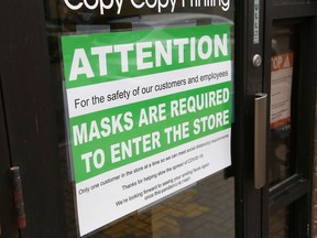 A sign posted at a downtown business in Sudbury requires customers to wear face masks when entering the store.