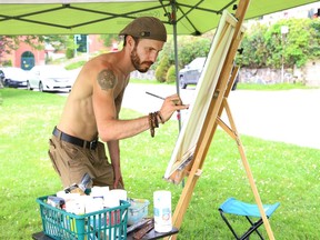 Local artist Brian Nori works on one of his paintings underneath a canopy near Bell Park in Sudbury, Ont. on Monday July 27, 2020. Nori said painting in front of people is "awesome exposure."