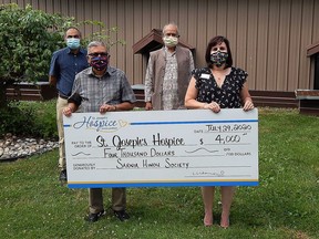 Sarnia Hindu Society members, left to right, Nirav Popawala, Mahesh Juthani and Uttam Bansal present St. Joseph's Hospice's Maria Muscedere with a cheque for $4,000 on July 29, money raised by society members during the past month to support local organizations coping with those affected by COVID-19.
(Carl Hnatyshyn/Sarnia This Week)