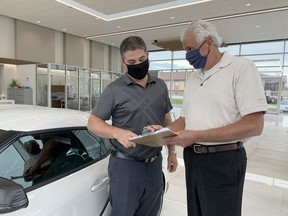 James Toyota sales representative Bob Larose, left, and Timmins Chamber president Val Venneri, who is also the car dealership's general manager, conduct business while wearing their masks inside the building Wednesday afternoon as the city begins to see the Porcupine Health Unit's new mask mandate roll out. As of Thursday, the public is required to wear a mask or face covering when entering indoor public spaces in Timmins.

ELENA DE LUIGI/The Daily Press