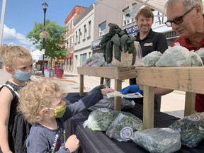 Madison Briere, 3, front, and her older sister Chloe, 5, are using their Farm to Fork market dollars to purchase kale and collard greens from Borealis Fresh Farms at the Urban Market in downtown Timmins Thursday afternoon. The market dollars can be used at any of the vendors set up at the Urban Market on Thursdays and at the Mountjoy Farmers' Market on Saturday mornings.

Elena De Luigi/The Daily Press