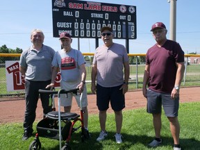 A new 'bigger and better' scoreboard, funded by Baseball Tillsonburg, has been installed at Sam Lamb Field in Tillsonburg. Games won't be played at the local two-diamond hardball facility, but it will be ready for use when leagues return in the spring. From left are Scott Vitias, president of Tillsonburg Minor Baseball, Sam Lamb, wearing his 2011 Sam Lamb Field Dedication Ceremony T-shirt, and Terry Lamb and Don Barnard, both members of Baseball Tillsonburg. (Chris Abbott/Norfolk Tillsonburg News)