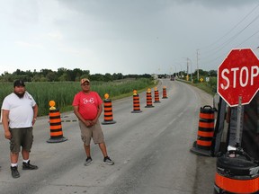 Walpole Island security guards Cody Miskokomon, left, and Brad Lallean enforce the bridge checkpoint leading into the First Nation on July 29. Walpole Island First Nation council voted to extend the checkpoint until the end of August on July 28. (Jake Romphf/Courier Press)