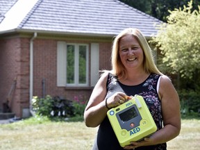 Cara Schmidt, the driving force behind Andrew's Legacy, poses with an AED machine at her Thamesford home. Last week, the Thames Valley District school board approved funding for the last 42 AED machines needed for local schools, a campaign Schmidt started after her son Andrew died of a cardiac event on an Oxford County soccer field. (Kathleen Saylors/Woodstock Sentinel-Review)