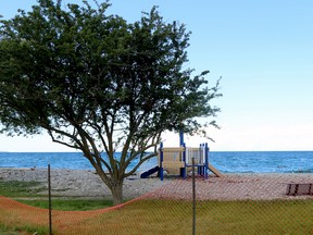 Fred Raper Park in Meaford on Thursday where sand and debris pushed up onto the beach by high water, wave rushes, and frequent storms have begun to swallow up play structures and benches. The park has been fenced-off since last fall. Greg Cowan/The Sun Times