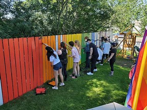 Around 40 people donned masks and gloves Sunday to join Jessi Hanks and her family in painting her white fence in rainbow colours to show their pride after receiving a hateful letter in the mail last week.
