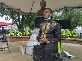 Thador Tekhli leads the gathering in taking a knee at the beginning of Saturday's Emancipation Day rally at BME Freedom Park in Chatham. Trevor Terfloth/Postmedia Network