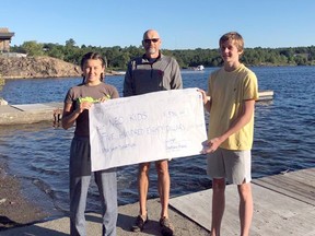 Swimmers Ivy Schulte-Hostedde and Ben Schell stand with Sudbury Laurentian Swim Club head coach Dean Henze.