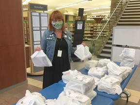 Strathcona County Library's Jessica Dolen gets bags of library materials ready for pickup by county residents. Since introducing a holds pickup service in June, the library has filled more than 30,000 requests for items. In-person holds will begin on Wednesday, August 12 Ñ the same day when the library will reopen for in-person visits. Photo Supplied