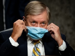 WASHINGTON, DC - AUGUST 05:  Committee Chairman Sen. Lindsey Graham (R-SC) removes his face mask before the start a Senate Judiciary Committee hearing on "Oversight of the Crossfire Hurricane Investigation" on Capitol Hill on August 5, 2020 in Washington, DC. Crossfire Hurricane was an FBI counterintelligence investigation relating to contacts between Russian officials and associates of Donald Trump. (Photo by Erin Schaff-Pool/Getty Images)