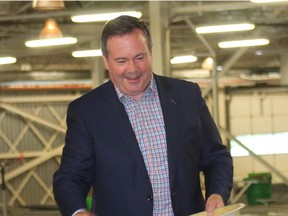 Premier Jason Kenney tries his hand at feeding some fish last week.  He and Environment & Parks Minister Jason Nixon were here to announce a $10.3 million investment in refurbishing the Cold Lake Fish Hatchery.