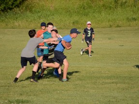 Bantam and peewee players played touch football during the Mustangs July summer camp. Photo by Riley Cassidy