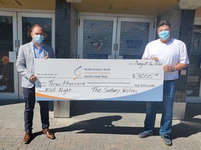 Sudbury Wolves owner Dario Zulich, right, presents a cheque for $3,000 to Anthony Keating from Heath Sciences North.