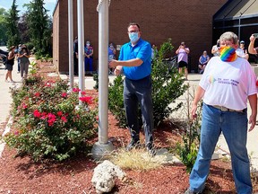 Chatham-Kent Mayor Darrin Canniff and CK Gay Pride Association president Marianne Willson raise the rainbow flag at Chatham-Kent Civic Centre Monday. (Handout/Postmedia Network)