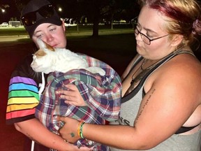 Callie Warner (left) and her sister Rachel Fournier hold a cat rescued from a fire-damaged building in downtown Stratford, one of four pets volunteer rescuers have been trying to coax out over the past two weeks. CONTRIBUTED