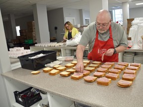 Owen Sound Hunger and Relief Effort board member Pat McDonough prepares lunches along with executive director Colleen Trask Seaman, in the background, at the OSHaRE's kitchen in downtown Owen Sound in this file photo from May 15. Demand for meals has remained high this summer.
(File photo)