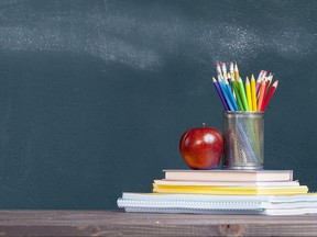 Pencil tray and an apple on notebooks on school teacher's desk