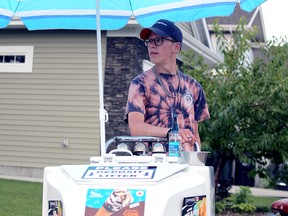 Harding Garratt sits at his Tie Dye Ice Cream Guy cart Thursday, Aug. 14, 2020. The teen, 15, has been doing so for months and had drawn praise in the community.