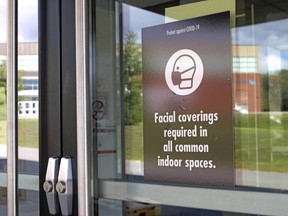 A sign advising visitors to wear a face covering is seen, Friday, at the entrance to the Harris Learning Library at Nipissing University. Michael Lee/The Nugget
