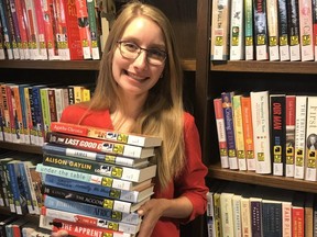 Amy Cole, an information services librarian with the Woodstock Public Library, holds a stack of great new large print books. The library received a donation from a Woodstock couple that will help them purchase more large prints books for local readers. (Handout)