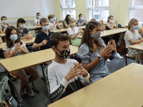 Students at a Berlin high school practise hand disinfection, August 10, 2020. Researchers have explored how different combination of class sizes and time in class could affect potential COVID-19 outbreaks. FABRIZIO BENSCH/REUTERS