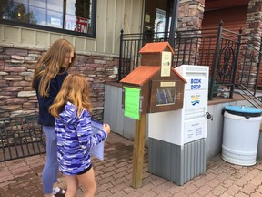 Two Vulcan area youth pick up their morse code sheets at the library as they prepare to venture out for the Bicycle Scavenger Hunt.