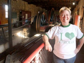 Liz Welsh stands next to the newly restored Fitzgerald Rig at the Petrolia Discovery oil heritage site. Paul Morden/Postmedia Network