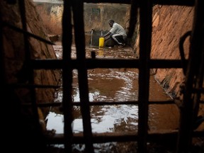 A man fills a jug with water at a water distribution point in the Naguru Go Down slum in Kampala.       WALTER ASTRADA/AFP/Getty Images file photo