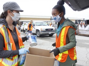 City of Timmins Environmental Co-ordinator Christina Beaton, left, and volunteer Keenyah Murray hold some of the household waste — like paint — people brought in to be disposed of during a special Hazardous and Special Waste Day at the Archie Dillon Sportsplex on Saturday. RICHA BHOSALE/THE DAILY PRESS/POSTMEDIA NETWORK