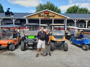 Dimitar Ljomov (left), chef at Bob 'n Buoys Bar & Boil, and restaurant manager Sherrie Dawson, are shown with golf cart owners at the Mitchell's Bay establishment. A petition has been circulating in Mitchell's Bay calling on Chatham-Kent council to allow golf carts on local roads. (Handout/Postmedia Network)