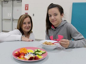 Lynn Paquette (left), with Noelle's Gift, is shown in this file photo visiting with pupil Mackenzie Sheppard during a breakfast program at P.E. McGibbon Public School in Sarnia. Student nutrition programs are among the services supported by Noelle's Gift, a Sarnia-area charity. File photo/Postmedia Network