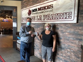 General Manager of Mr. Mikes, Stan Killam, presenting Dawn Froese, Executive Director of Big Brothers Big Sisters of Portage la Prairie, with a cheque for $3493.50 as proceeds from Mr. Mikes Big BBQ on July 31, 2020.