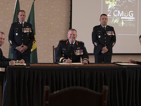 The outgoing Commander, 2 Canadian Mechanized Brigade Group (2 CMBG) Col. J. Adair signs over authority of 2 CMBG to the incoming commander, Col.l J.E. Landry, with the commander, 4th Canadian Division Brig.-Gen.l C. Mialkowski presiding during the virtual change of command ceremony at Garrison Petawawa. The ceremony which was held at the Normandy Officers Mess Friday, Aug. 21 was attended by only a handful of guests to respect COVID-19 precautions and was live-streamed on the 2 CMBG Facebook page. From left, Col. J.E. Landry, Chief Warrant Officer K. Olstad, Brig.-Gen. C. Mialkowski, Chief Warrant Officer M.P. Forest and Col. J. Adair. 
Photo By: Able Seaman Elizabeth Ross